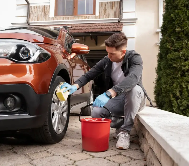 Lavage auto à domicile Pouzolles : professionnel intervenant sur un véhicule